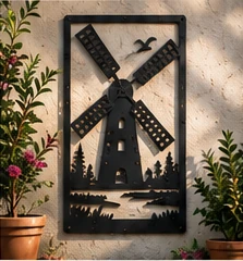 Windmill steel wall art surrounded by garden foliage